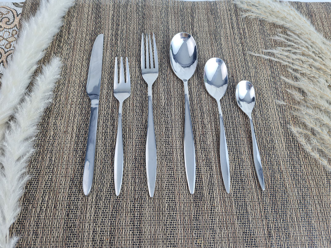 Set of stainless steel silver cutlery including knives, forks, and spoons