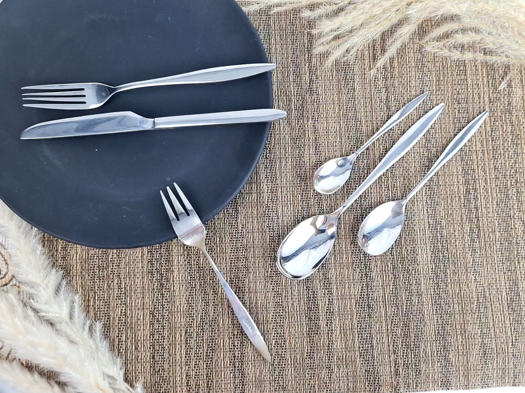Set of stainless steel silver cutlery including knives, forks, and spoons