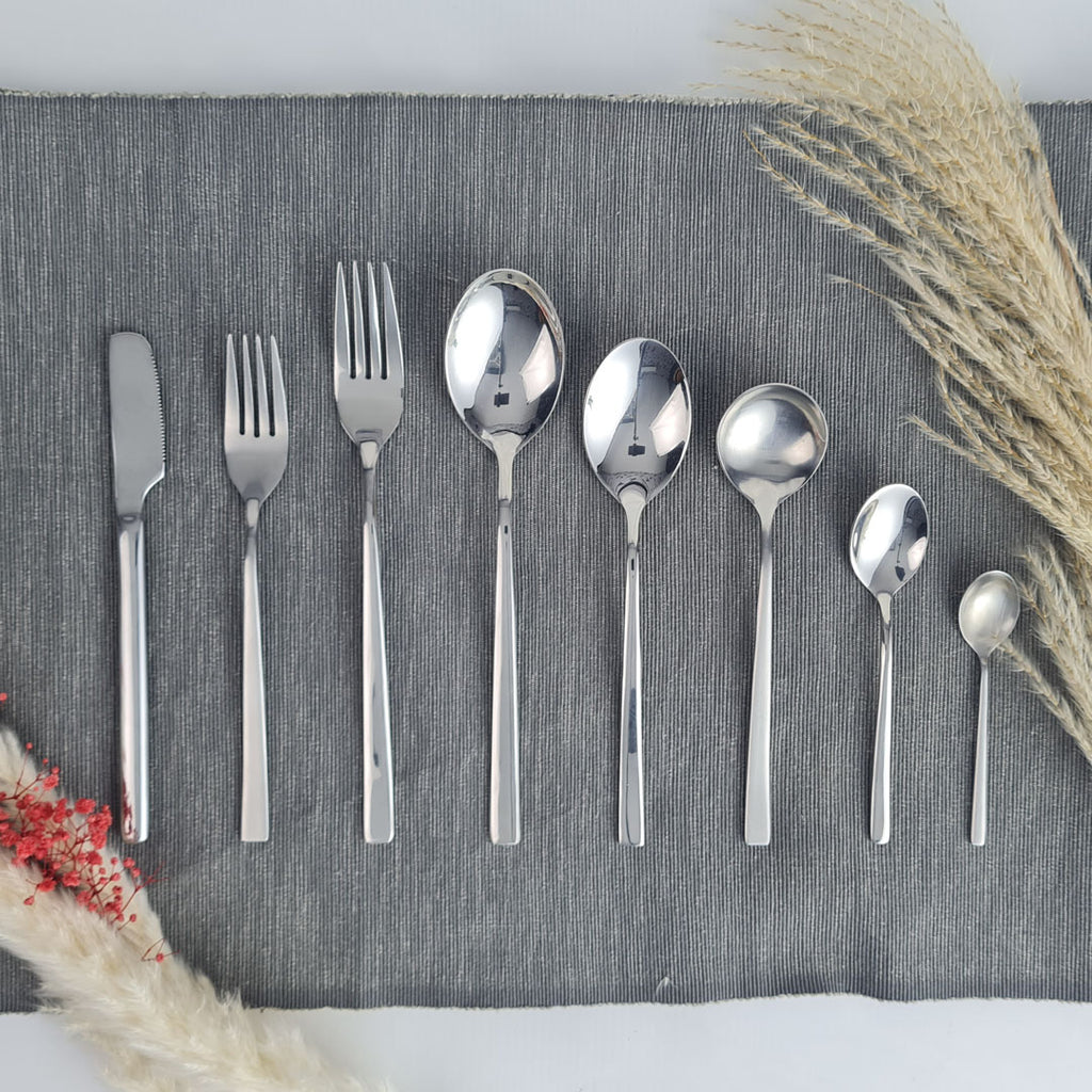 Set of stainless steel silver cutlery including knives, forks, and spoons.