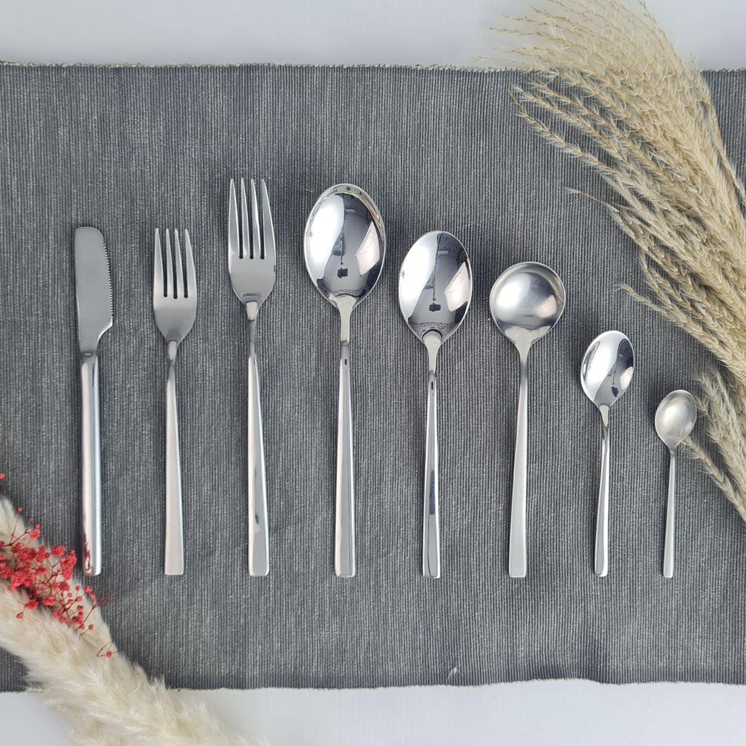 Set of stainless steel silver cutlery including knives, forks, and spoons.