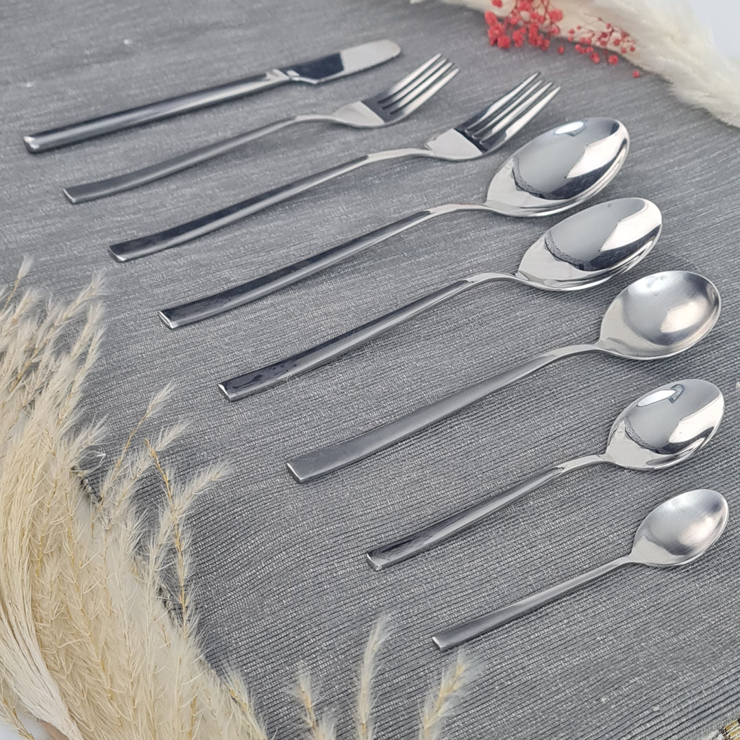Set of stainless steel silver cutlery including knives, forks, and spoons.