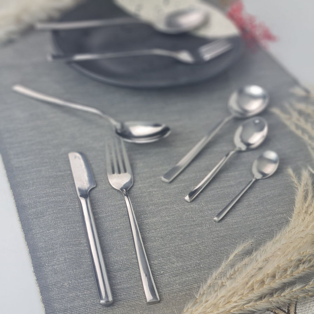 Set of stainless steel silver cutlery including knives, forks, and spoons.