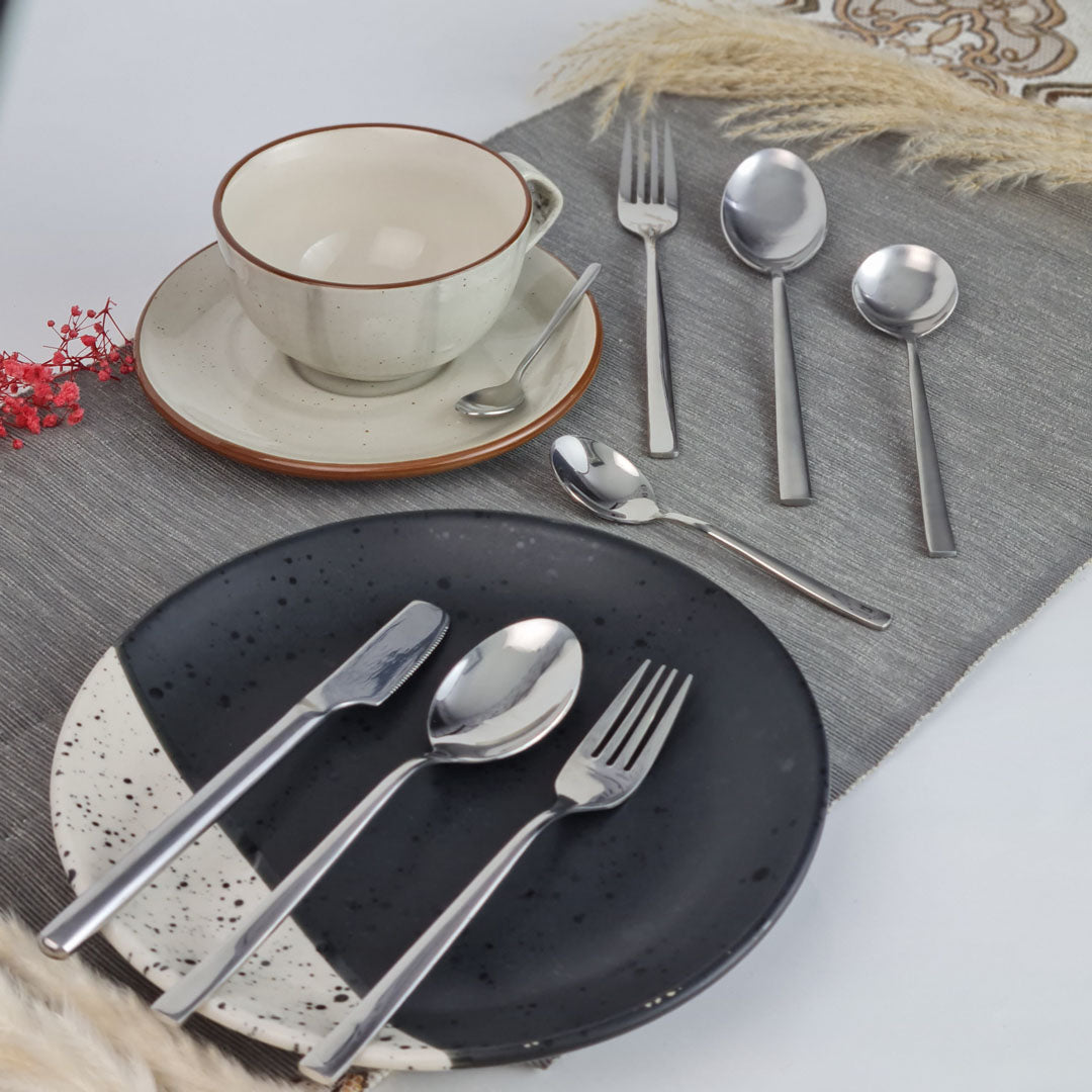 Set of stainless steel silver cutlery including knives, forks, and spoons.
