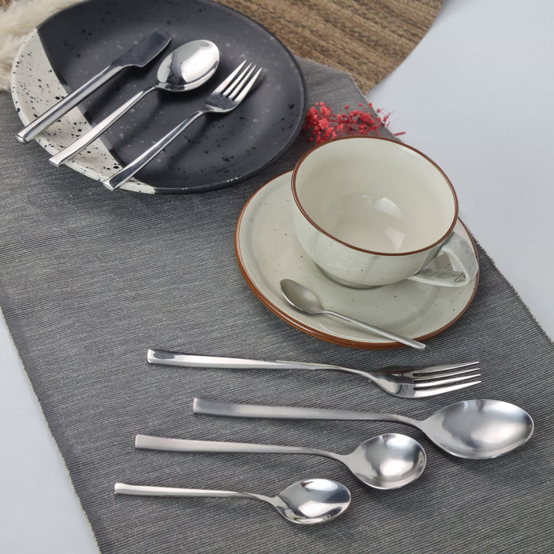 Set of stainless steel silver cutlery including knives, forks, and spoons.